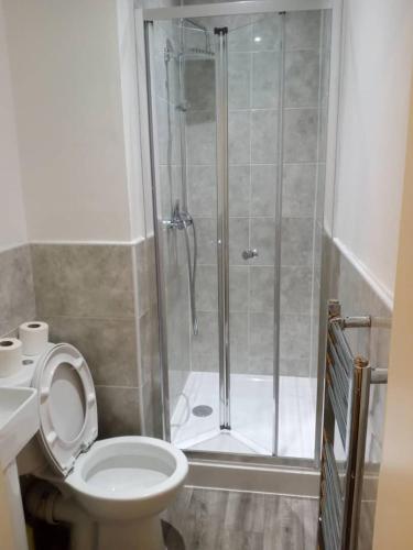 a bathroom with a shower and a white toilet at Ensuite Double-bed H3 close to Burnley city centre in Burnley