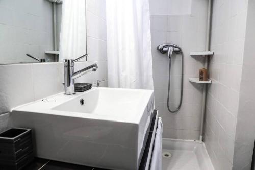 a white bathroom with a sink and a shower at F2 Cosy Centre Ville in Ajaccio