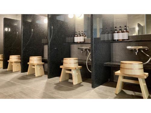 een badkamer met een rij krukken in een kamer bij URAKUSATSU TOU - Vacation STAY 75063v in Kusatsu