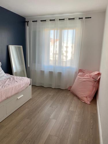 a bedroom with a bed and a large window at Superbe appart à Clermont-Ferrand Parking privé in Clermont-Ferrand