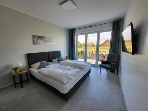 sypialnia z łóżkiem i dużym oknem w obiekcie Robson Beach I Sauna, Jacuzzi w mieście Międzywodzie