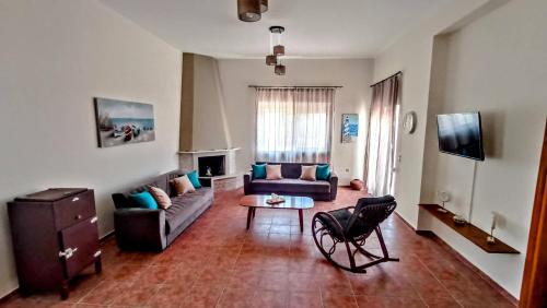 a living room with a couch and a table at Dimitra - Kattavia surf houses in Kattavía