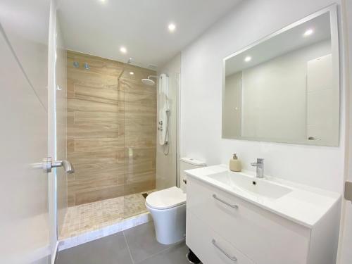 een badkamer met een toilet, een wastafel en een douche bij Townhouse w/sea view & garden in Estepona