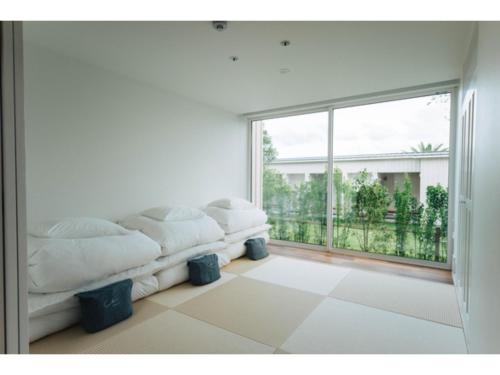 sala de estar blanca con sofá y ventana grande en Colorit Goto Islands - Vacation STAY 61533v, en Goto