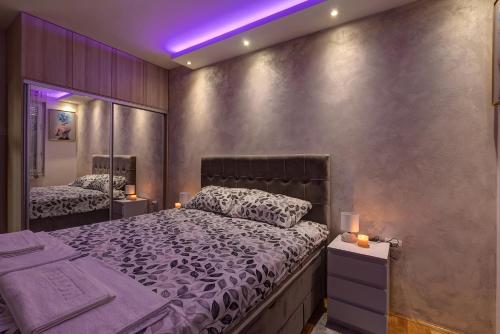 1 dormitorio con cama grande e iluminación púrpura en PORTOFINO, with private PARKING, en Novi Sad
