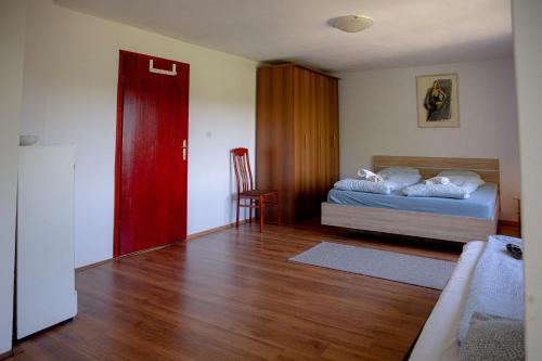 1 dormitorio con 1 cama y puerta roja en Rustic House in a Beautiful Village, en Cerklje ob Krki