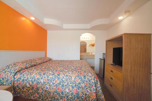 1 dormitorio con 1 cama y TV de pantalla plana en Budget Inn By OYO Corpus Christi Beach, en Corpus Christi