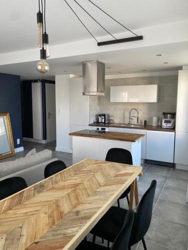 a kitchen with a wooden table and chairs at Superbe appart à Clermont-Ferrand Parking privé in Clermont-Ferrand