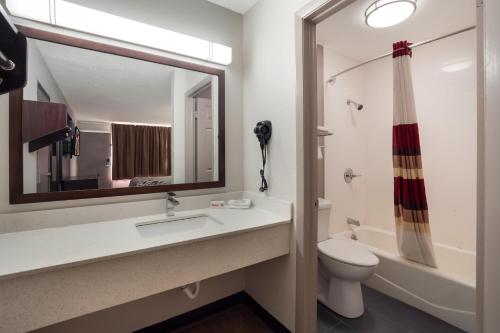 ein Badezimmer mit einem Waschbecken, einem WC und einem Spiegel in der Unterkunft Red Roof Inn Columbia, SC Airport in Columbia