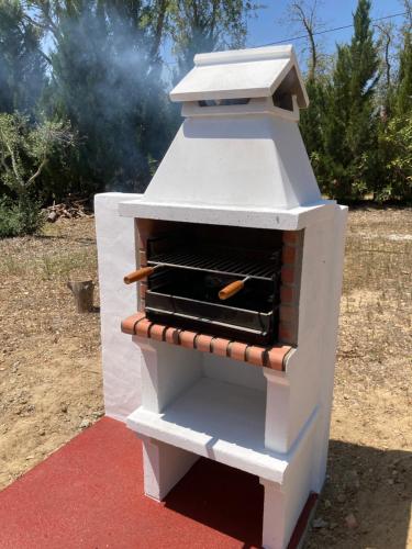 a white outdoor oven with hot dogs in it at Casa no Monte Ninho das Perdizes perto Cercal do Alentejo in Vale de Água