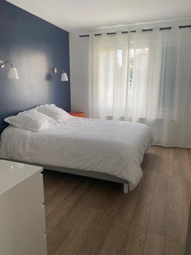 - une chambre avec un grand lit et du parquet dans l'établissement Superbe appart à Clermont-Ferrand Parking privé, à Clermont-Ferrand