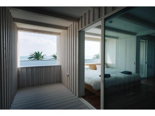 a bedroom with a bed and a view of the ocean at Colorit Goto Islands - Vacation STAY 61530v in Goto