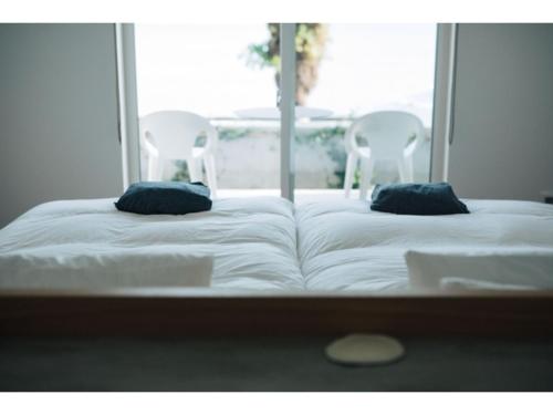 1 cama con 2 almohadas en una habitación con ventana en Colorit Goto Islands - Vacation STAY 61529v, en Goto