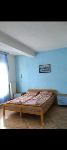 1 dormitorio con 1 cama en una pared azul en Hotel Riva, en Resen