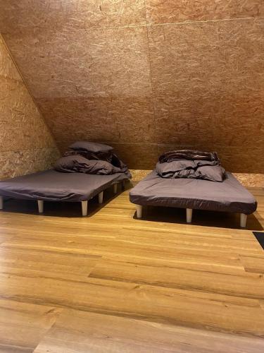 two beds in a room with wooden floors at tiny resort misawa - Vacation STAY 14682 in Misawa