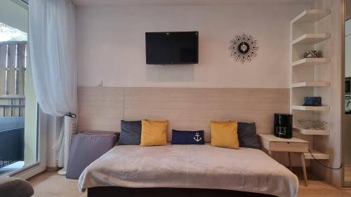 1 dormitorio con 1 cama con almohadas amarillas y azules en APARTAMENT RELAX BLUE MARE en Łukęcin