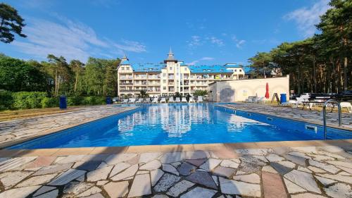 a swimming pool with a hotel in the background at APARTAMENT RELAX BLUE MARE in Łukęcin