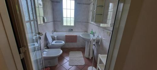 e bagno con lavandino, servizi igienici e vasca. di MaLù House a Villasimius