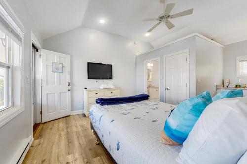 a bedroom with a bed with blue pillows on it at Beach Pleasure in Hampton