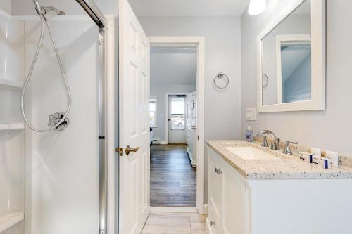 a white bathroom with a sink and a mirror at Beach Pleasure in Hampton