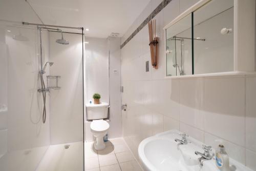 a bathroom with a toilet and a sink and a shower at Beautiful 3BR Home Close to Town Centre in Kent