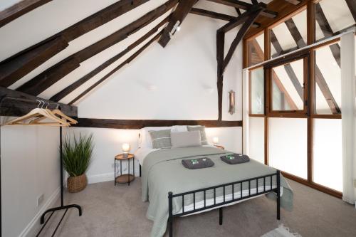 - une chambre avec un lit dans une pièce dotée de fenêtres dans l'établissement Beautiful 3BR Home Close to Town Centre, à Kent