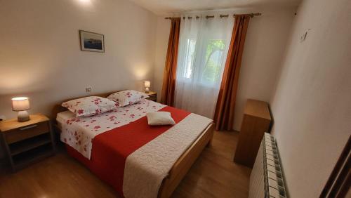 een kleine slaapkamer met een bed en een raam bij Country Home Močilo, Zagvozd in Zagvozd