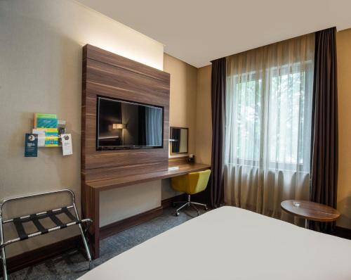 a hotel room with a bed and a tv and a desk at Holiday Inn Istanbul - Kadikoy by IHG in Istanbul