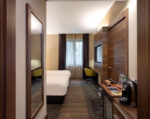 a hotel room with a bed and a desk and a mirror at Holiday Inn Istanbul - Kadikoy by IHG in Istanbul