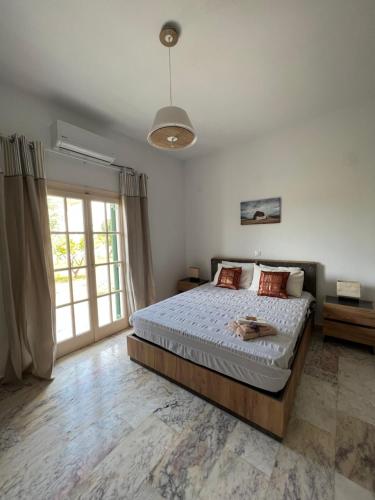 a bedroom with a bed and a large window at ALAMENA II in Skiros