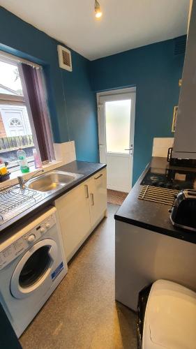 a kitchen with a sink and a washing machine at Contractors, City Centre, Parking, 3 Double Rooms, Netflix, Cosy! in Coventry
