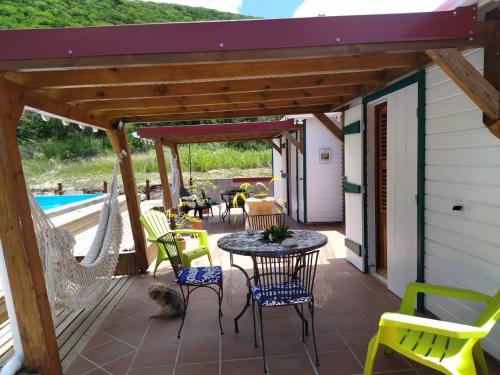 a patio with a hammock and a table and chairs at Aichi's lodges -gîtes in Capesterre-de-Marie-Galante