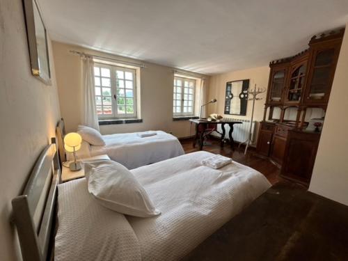 a bedroom with two beds and a desk with a table at Biescas Apartamento Casa Josito La Cadiera in Biescas