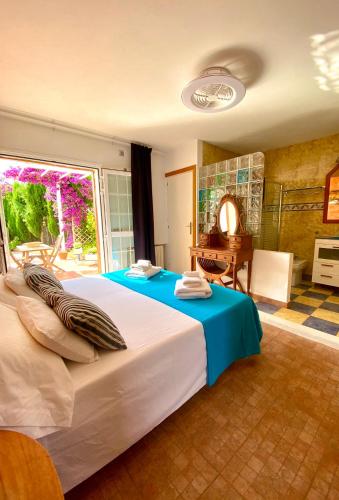 a bedroom with a large white bed and a desk at CAN DAMIA 2 in Cala Saona