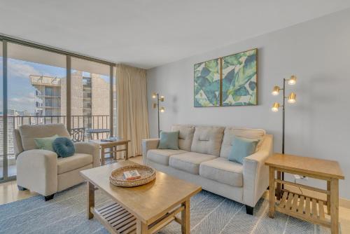 a living room with a couch and a table at Beach Oasis with Ocean & City Views with FREE Parking! in Honolulu