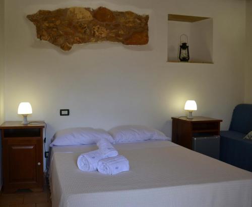 a bedroom with a bed with two towels on it at HOTEL Cala Buguto in Custonaci