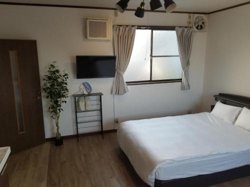 a bedroom with a white bed and a window at Guest House Tatara - Vacation STAY 61943v in Yasugi