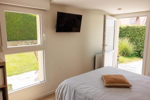 Schlafzimmer mit einem Bett und einem Flachbild-TV in der Unterkunft Pierre de Lune in Bayeux