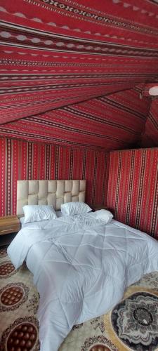 a bedroom with a large bed with a red wall at Red Twilight Camp in Disah