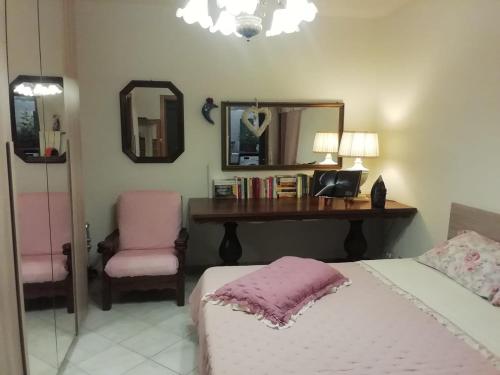 Schlafzimmer mit einem Bett und einem Schreibtisch mit einem Spiegel in der Unterkunft Small Wave in Viareggio