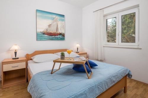 een slaapkamer met een bed en een tafel met daarop een boot bij Apartments More in Klenovica