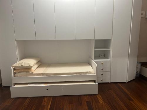 a white room with two beds and a cabinet at Tevere 20 House in Monza