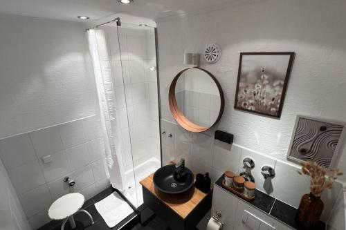 a bathroom with a sink and a mirror at BOSTEL 88 - Apartment, Altstadt, Klimaanlage, Aufzug, Hunde willkommen in Moers