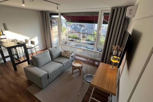 a living room with a couch and a large window at BOSTEL 88 - Apartment, Altstadt, Klimaanlage, Aufzug, Hunde willkommen in Moers