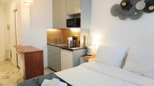 une chambre avec un lit et une petite cuisine dans l'établissement Proche Croisette, Studio moderne by Palmazur Vacances, à Cannes