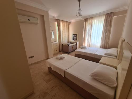 a hotel room with two beds and a window at Alanya gold city villa in Alanya