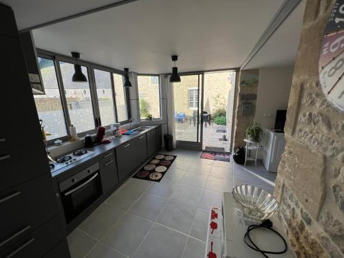 une cuisine avec un évier et un comptoir avec des fenêtres dans l'établissement Cottage OVERLORD - 6 personnes - Plages du débarquement, à Formigny