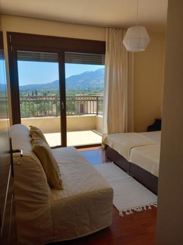 a bedroom with two beds and a large window at Villa Panoramica in Pylíon