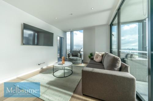 a living room with a couch and a table at Melbourne Private Apartments - Collins Wharf Waterfront, Docklands in Melbourne