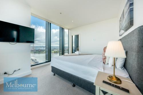 a bedroom with a bed and a large window at Melbourne Private Apartments - Collins Wharf Waterfront, Docklands in Melbourne